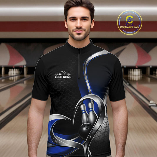 Male model in a bowling lane wearing a black and blue quarter zip shirt with honeycomb accents and a heart-framed bowling strike graphic.