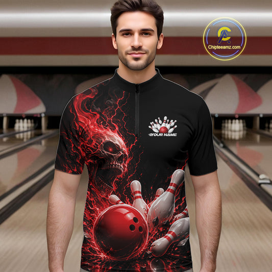 Front view of a male model in a bowling alley wearing a black bowling quarter zip shirt featuring a red fiery skull design with lightning striking a bowling ball and pins and a custom name.