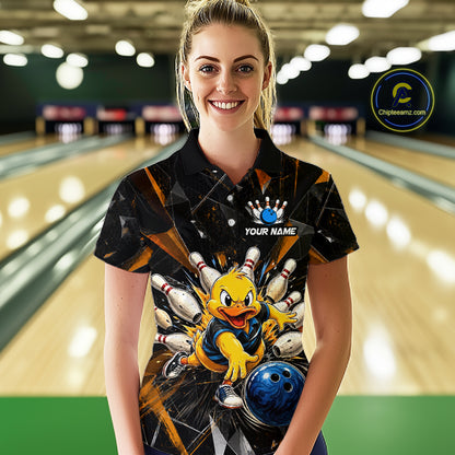Female model wearing a custom black bowling polo shirt front view featuring a playful cartoon duck, bowling ball, bowling pins and orange cracked lightning pattern at the bowling alley