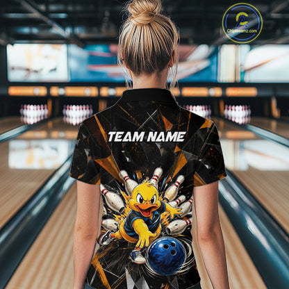 Female model wearing a custom black duck bowling polo shirt back view displaying the personalized team name above a playful cartoon graphic at the bowling alley