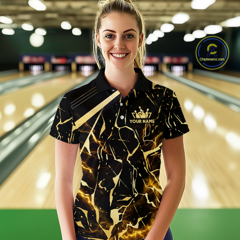 Female model wearing a custom black gold bowling polo shirt front view featuring a glowing bowling ball, lightning energy effect and black gold marble crack pattern at the bowling alley