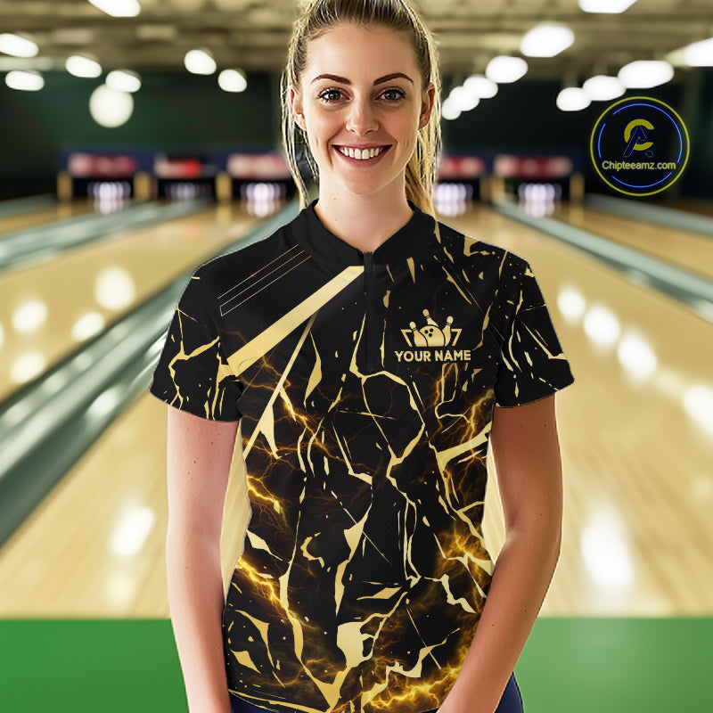 Female model wearing a custom black gold bowling quarter-zip shirt front view featuring a glowing bowling ball, lightning energy effect and black gold marble crack pattern at the bowling alley