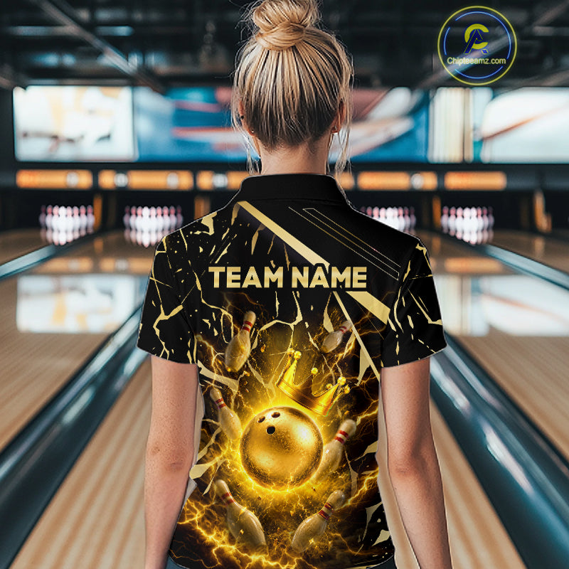 Female model wearing a custom black gold bowling polo shirt back view displaying the personalized team name above a glowing bowling ball with lightning energy artwork at the bowling alley