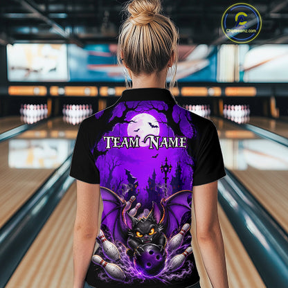 A woman viewed from behind wearing a black short-sleeve collared shirt with a large purple Halloween-themed graphic on the back, featuring a bat, haunted house, and the text 'TEAM_NAME'. The background shows a bowling alley with lanes and pins.