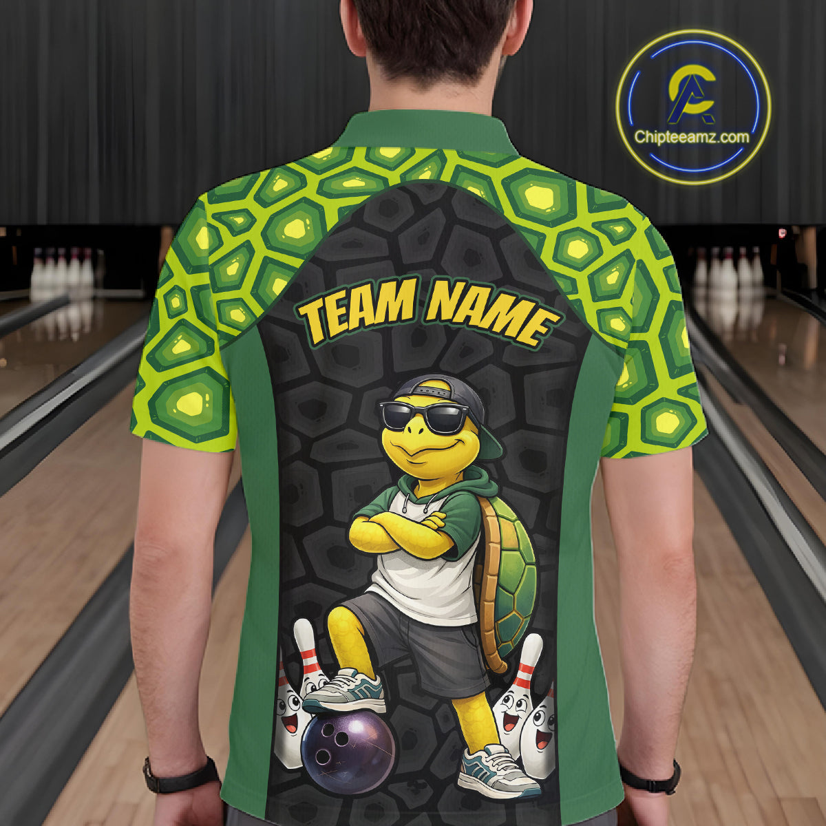 Man wearing custom green turtle bowling polo shirt back view featuring a bowling ball and green hexagon pattern, displaying Team Name, at the bowling alley