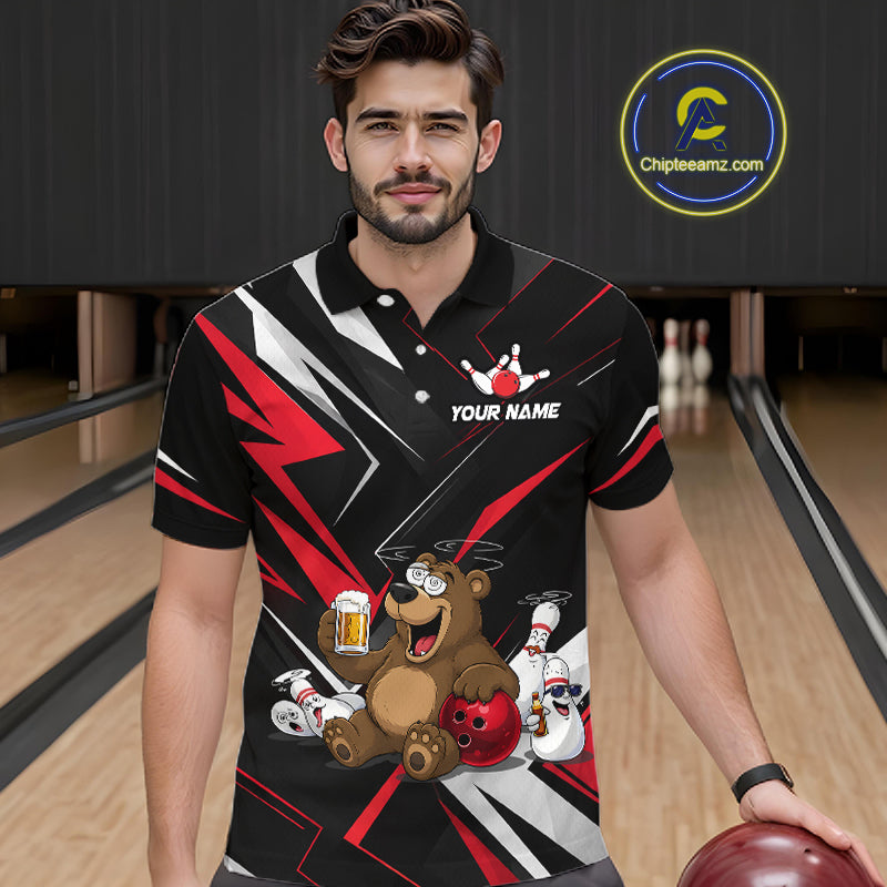 Man wearing a black bowling-themed shirt with a bear design in a bowling alley.