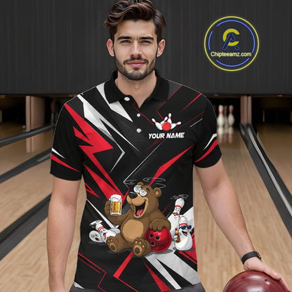 Man wearing a black bowling-themed shirt with a bear design in a bowling alley.