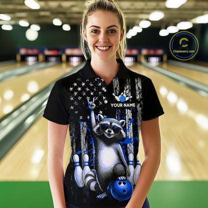 Woman wearing a black shirt with a raccoon design in a bowling alley.