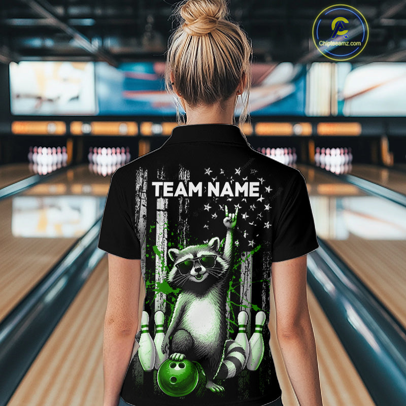 Person wearing a black shirt with a raccoon graphic and 'TEAM NAME' text in a bowling alley.