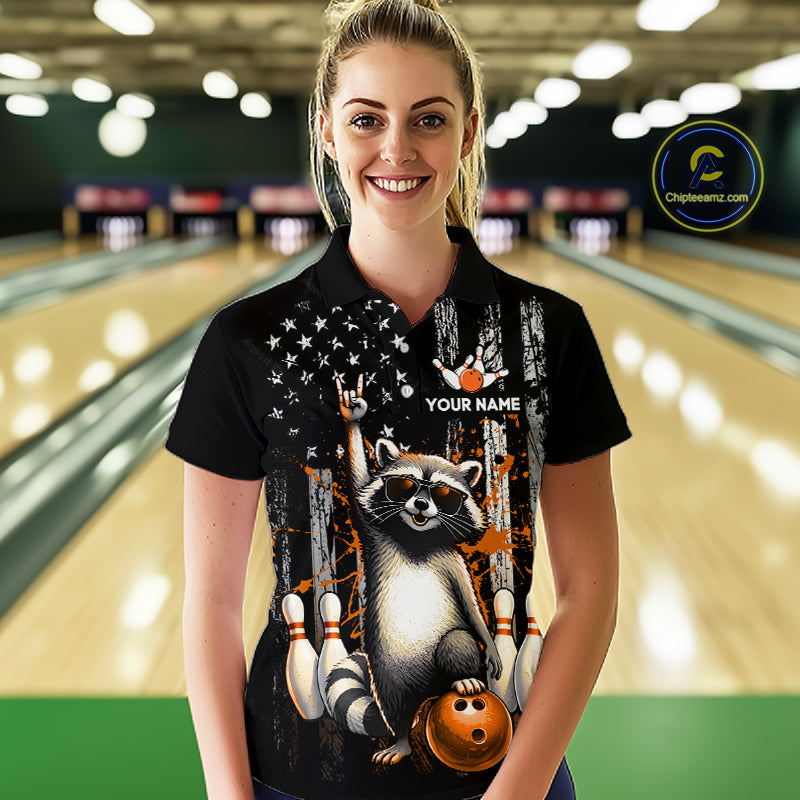 Woman wearing a black shirt with a raccoon graphic in a bowling alley.