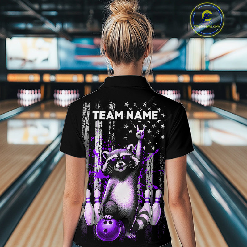 Person wearing a black shirt with a raccoon graphic and 'TEAM NAME' text in a bowling alley.