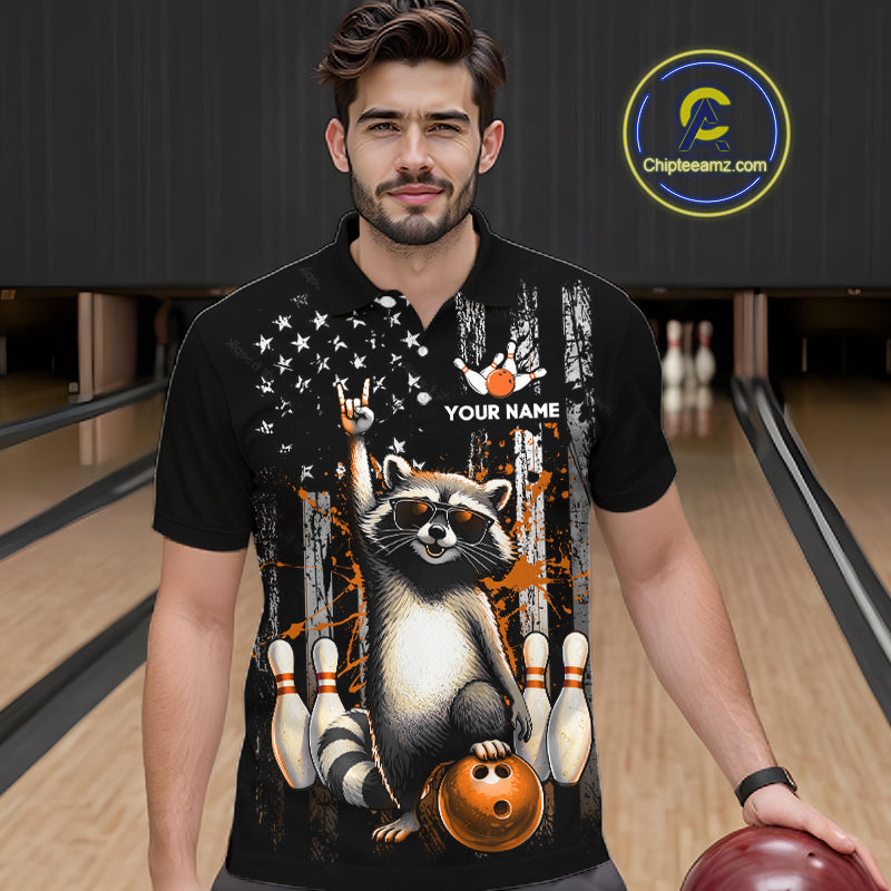 Man wearing a black shirt with a raccoon graphic in a bowling alley.