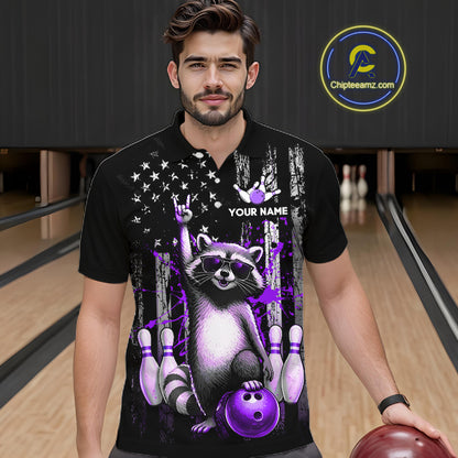 Man wearing a black shirt with a raccoon graphic holding a bowling ball on a bowling alley.