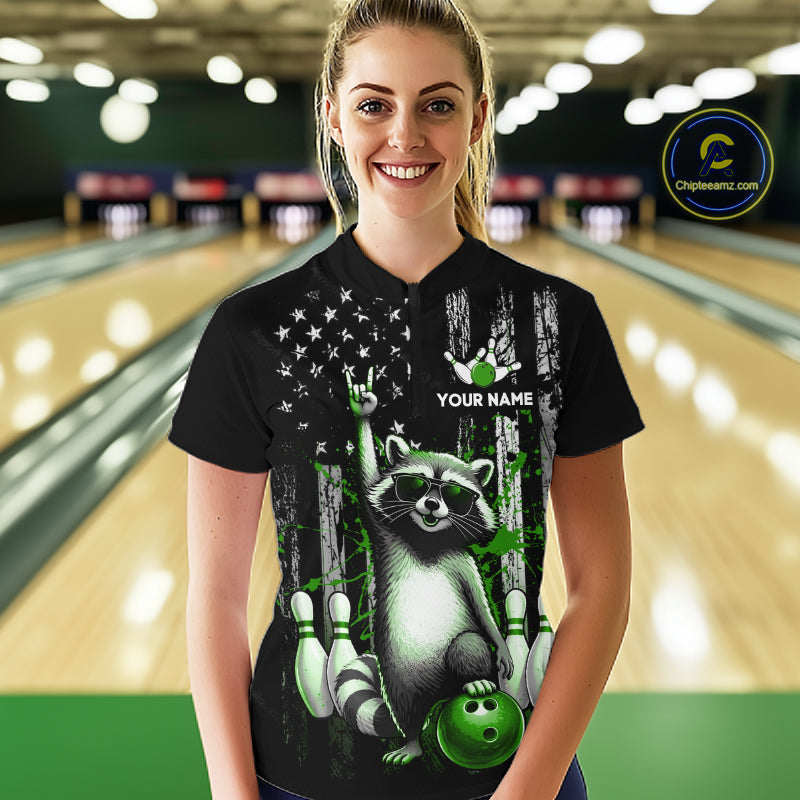 Person wearing a black shirt with a raccoon design in a bowling alley.