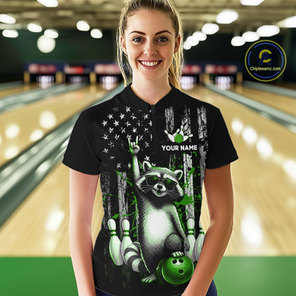 Person wearing a black shirt with a raccoon design in a bowling alley.