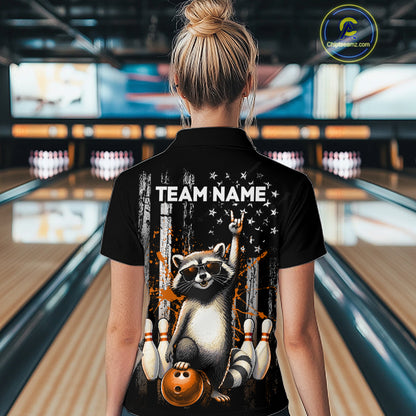 Person wearing a black shirt with a raccoon graphic and 'TEAM NAME' text in a bowling alley.