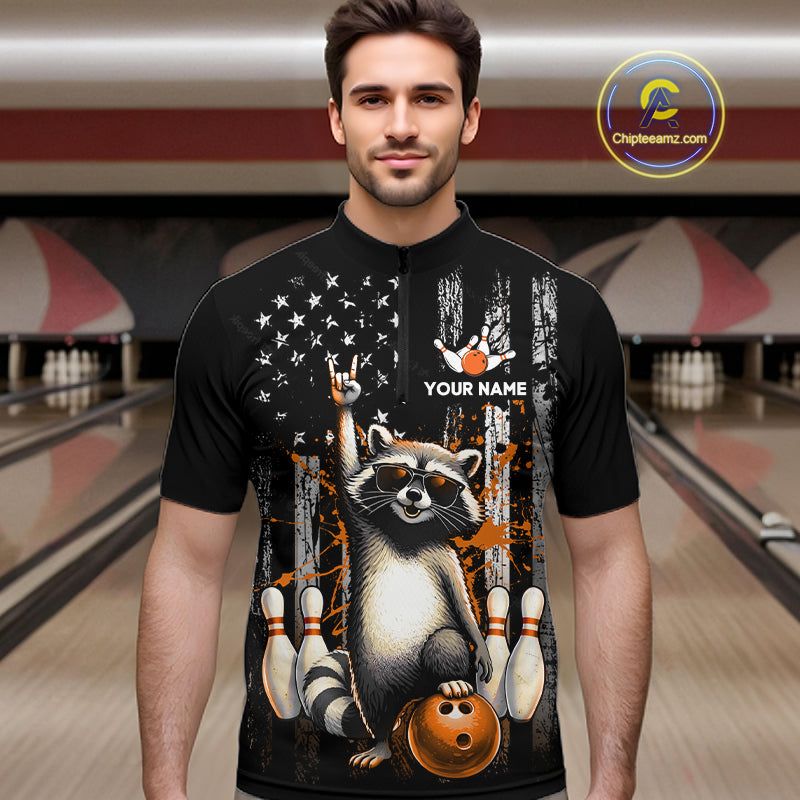 Man wearing a black shirt with a raccoon graphic and text in a bowling alley.