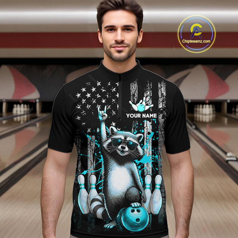 Man wearing a black shirt with a raccoon design in a bowling alley.