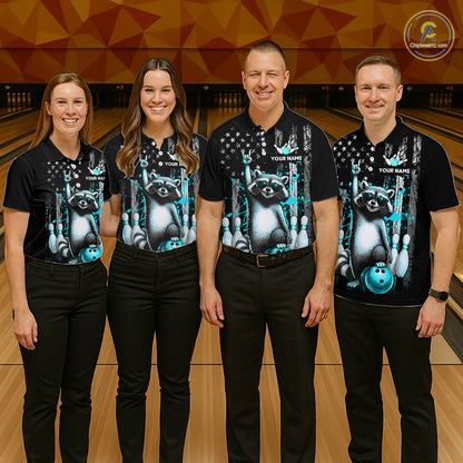 Four people wearing matching black shirts with a raccoon and bowling ball design on a bowling alley.
