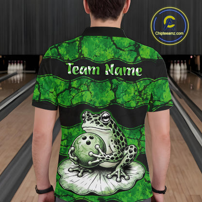 A person viewed from behind wearing a short-sleeve bowling-themed polo shirt with a green frog and bowling ball graphic on the back, standing in a bowling alley. The shirt has a black collar and shoulders, green marbled pattern, 'Team Name' text, and a large frog sitting on a bowling ball.
