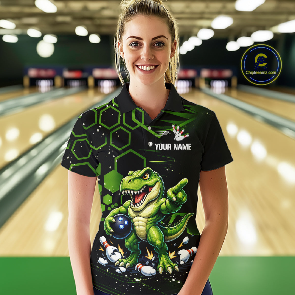 A woman wearing a black and green bowling-themed polo shirt with a dinosaur graphic, standing in a bowling alley. The shirt features a green T-Rex holding bowling balls, green hexagonal patterns, and a customizable name print area.