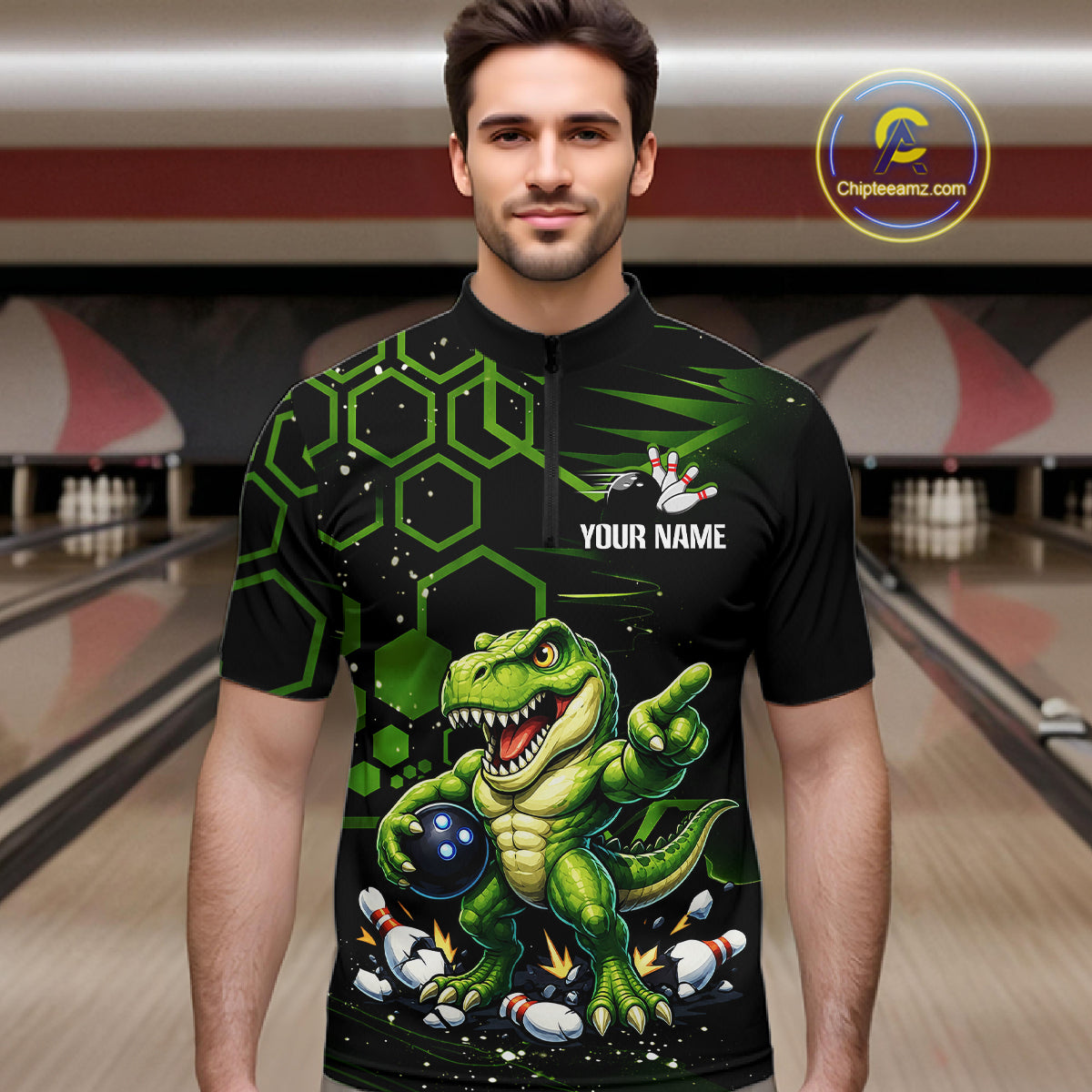 A man wearing a black short-sleeve bowling jersey with a green cartoon dinosaur graphic, bowling pins, and the text 'YOUR NAME' on the chest. The background shows a blurred bowling alley.
