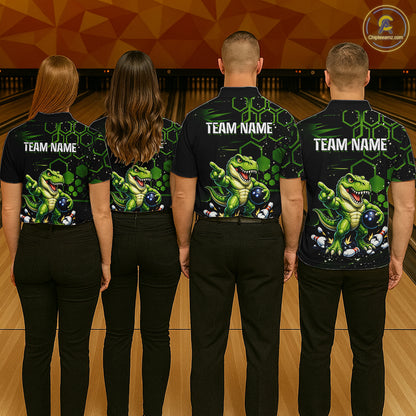 Four people standing with their backs to the camera in a bowling alley, wearing matching black bowling shirts with a green dinosaur graphic and the text 'TEAM NAME' on the back. 