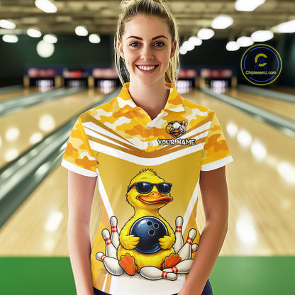 Female model wearing a custom yellow duck bowling polo shirt front view featuring a cool cartoon duck wearing sunglasses, bowling ball, bowling pins and yellow camouflage pattern at the bowling alley