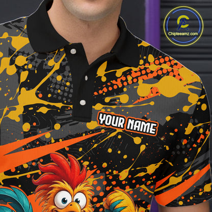 Close-up front view of a custom orange rooster bowling polo shirt showing the personalized player name, fierce cartoon rooster graphic and black orange paint splatter design