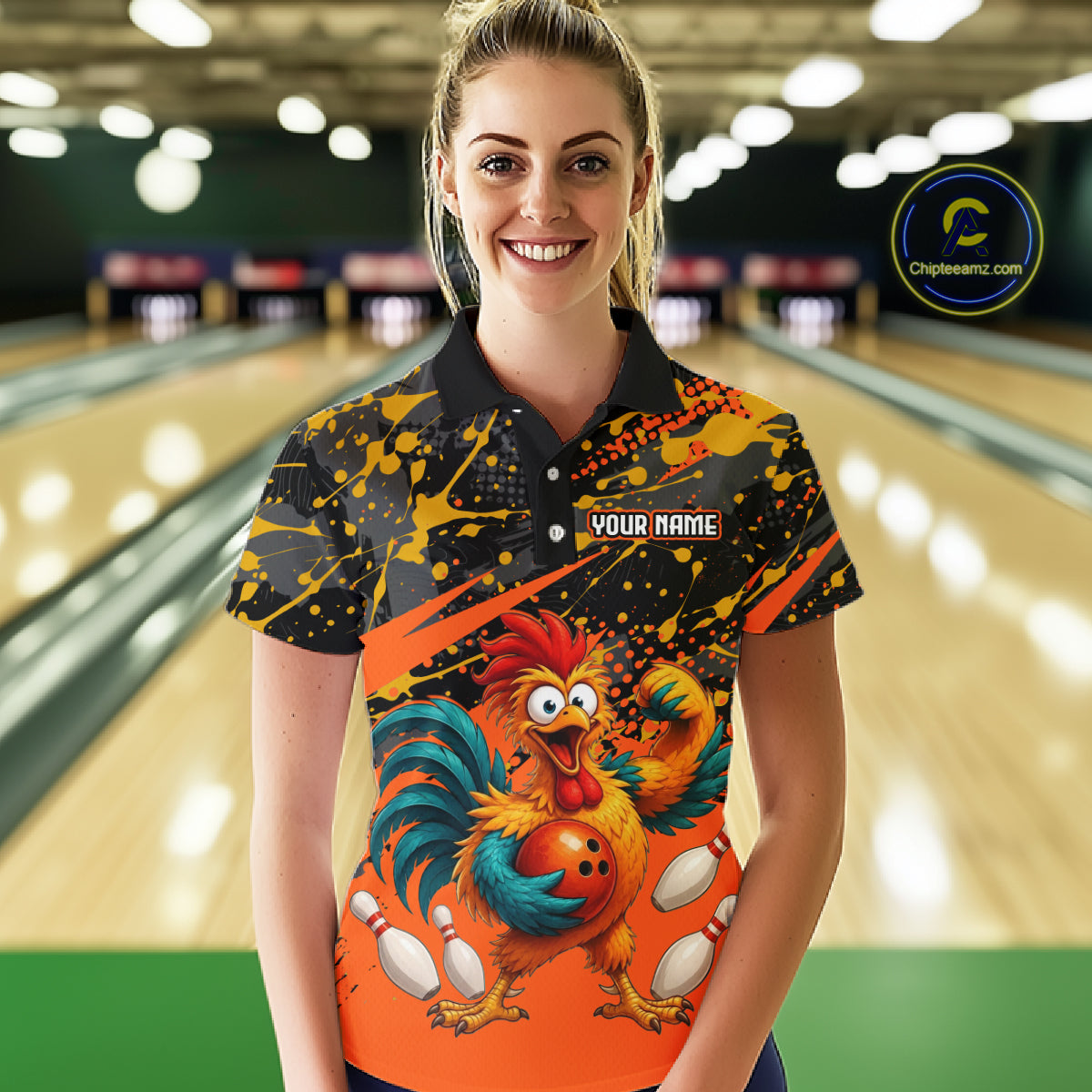 Female model wearing a custom orange rooster bowling polo shirt front view featuring a fierce cartoon rooster, bowling ball, bowling pins and black yellow paint splatter pattern at the bowling alley