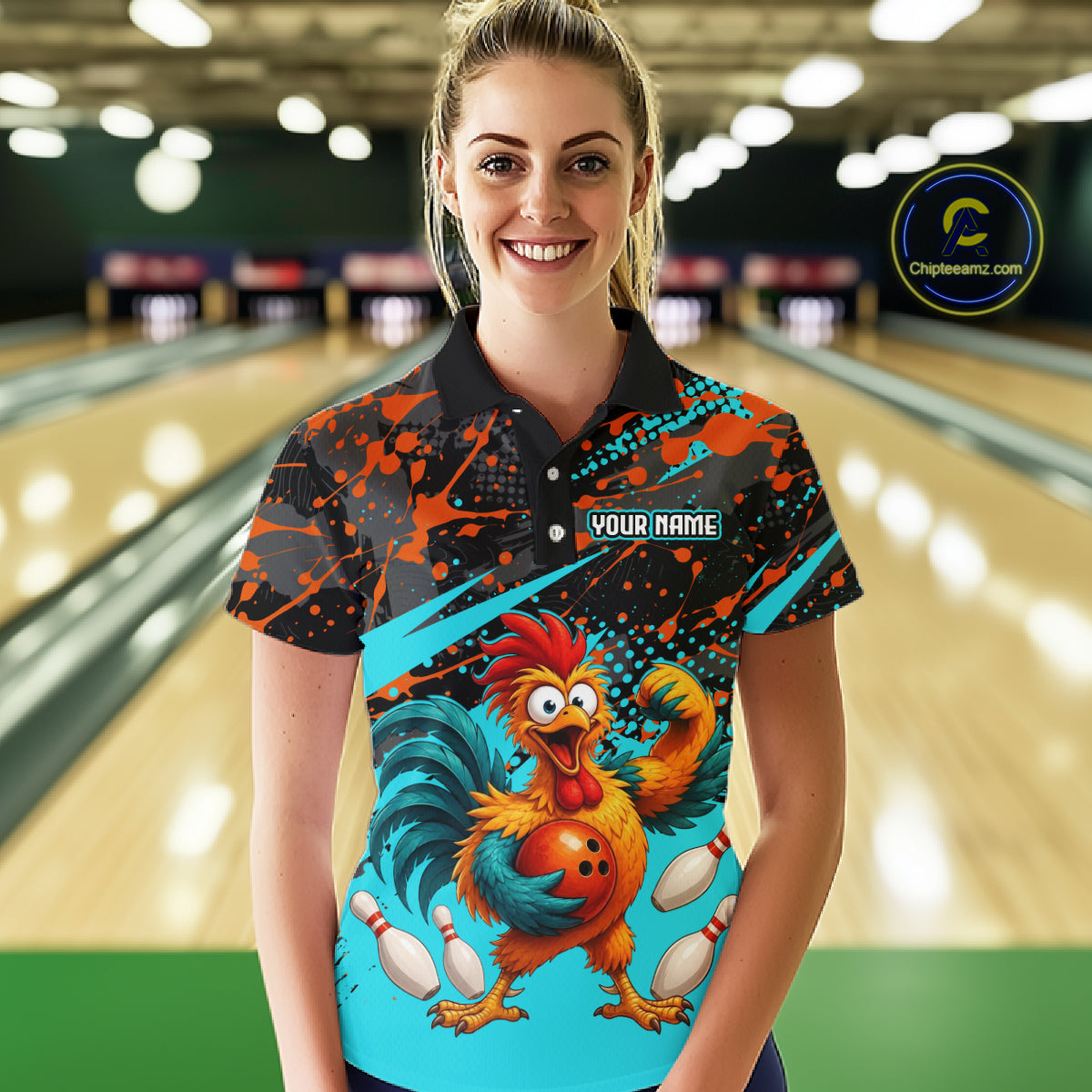 Female model wearing a custom black red rooster bowling polo shirt front view featuring a fierce cartoon rooster, bowling ball, bowling pins and orange turquoise paint splash pattern at the bowling alley