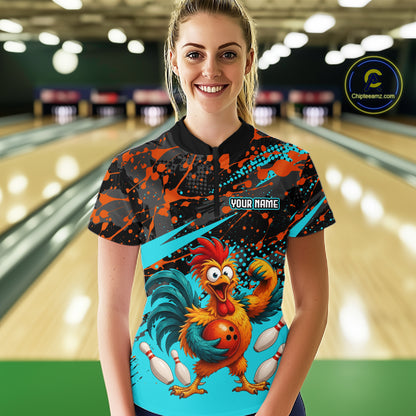 Female model wearing a custom black turquoise rooster bowling polo shirt front view featuring a fierce cartoon rooster, bowling ball, bowling pins and turquoise orange paint splash pattern at the bowling alley