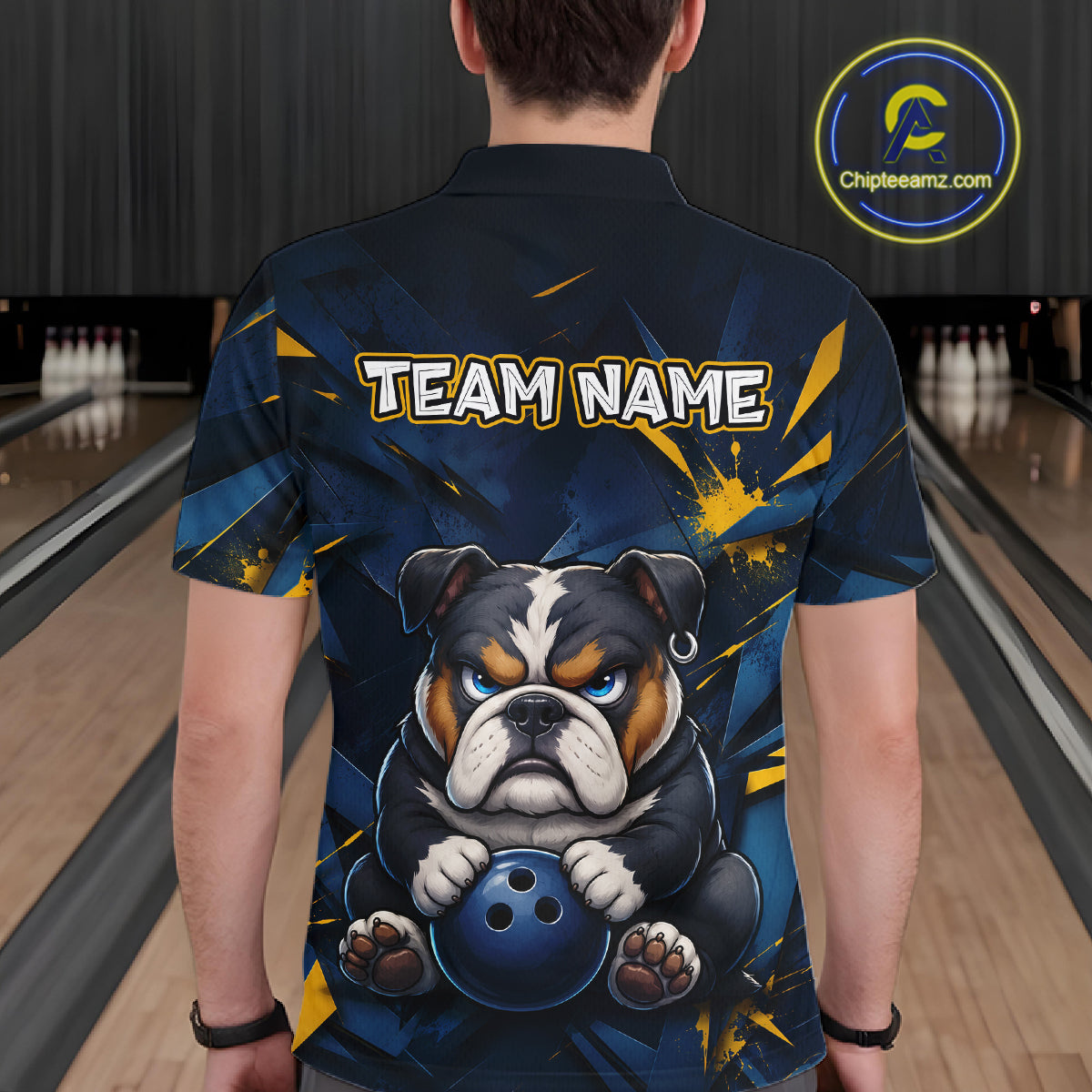 Male model wearing a custom blue bulldog bowling polo shirt back view displaying the personalized team name above a fierce cartoon bulldog graphic at the bowling alley