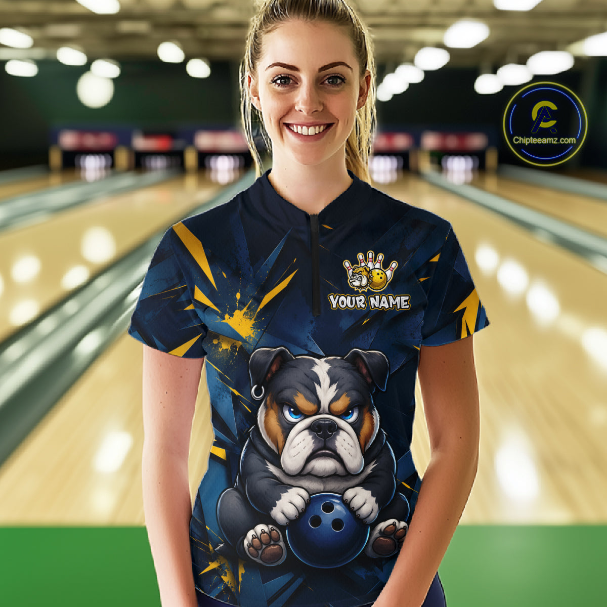 Female model wearing a custom blue bulldog bowling quarter-zip shirt front view featuring a fierce cartoon bulldog, bowling ball, gold lightning accents and navy blue abstract pattern at the bowling alley