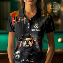 Load image into Gallery viewer, A front view of a custom blue and yellow billiards polo shirt worn by a female model . The shirt features  a cartoon hip hop bulldog and an 8-ball on the front. A 'YOUR NAME' text placeholder . The background is a blurred billiards room with a green pool table.