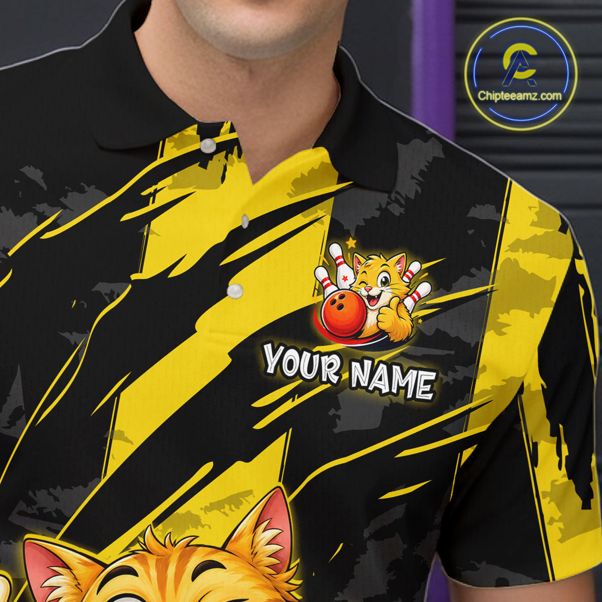Close-up front view of a custom black yellow cat bowling polo shirt showing the personalized player name, playful cartoon cat graphic and yellow black paint stroke design