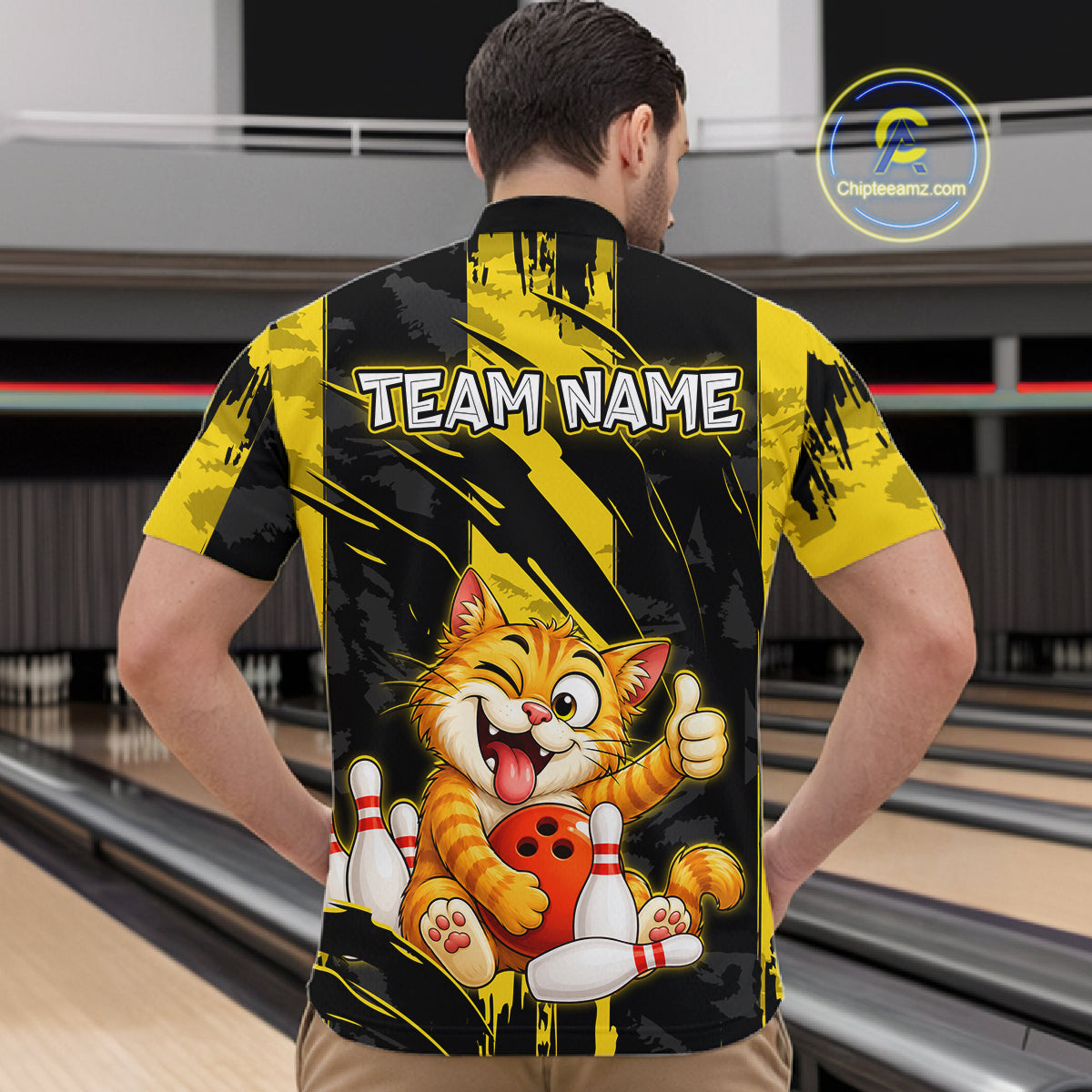 Male model wearing a custom black yellow cat bowling quarter-zip shirt back view displaying the personalized team name above a playful cartoon cat graphic at the bowling alley