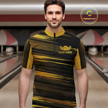 Load image into Gallery viewer, Male model wearing a custom black gold bowling quarter-zip shirt front view featuring a gold bowling ball emblem, dynamic gold brush stroke pattern and striped design at the bowling alley