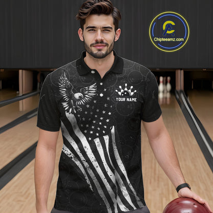 Male model wearing a custom black patriotic bowling polo shirt front view featuring a distressed American flag, bald eagle emblem and grunge pattern at the bowling alley