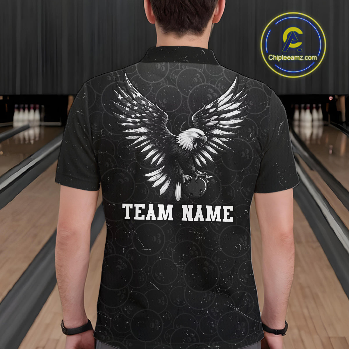 Male model wearing a custom black patriotic bowling polo shirt back view displaying the personalized team name below a spread-wing bald eagle graphic at the bowling alley