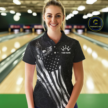 Female model wearing a custom black patriotic bowling polo shirt front view featuring a distressed American flag, bald eagle emblem and grunge pattern at the bowling alley