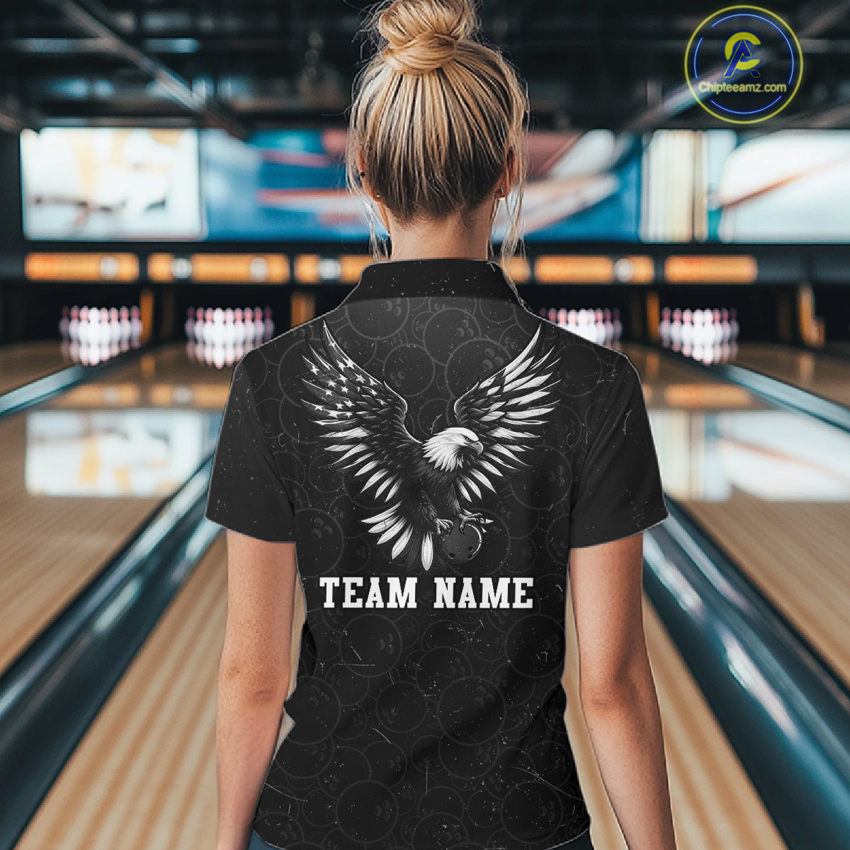 Male model wearing a custom black patriotic bowling polo shirt back view displaying the personalized team name below a spread-wing bald eagle graphic at the bowling alley