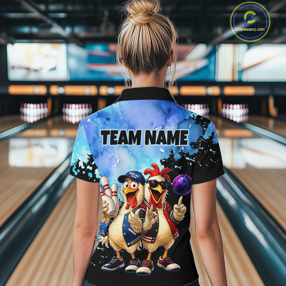 Person wearing a colorful bowling shirt with cartoon chickens and 'TEAM NAME' text in a bowling alley.