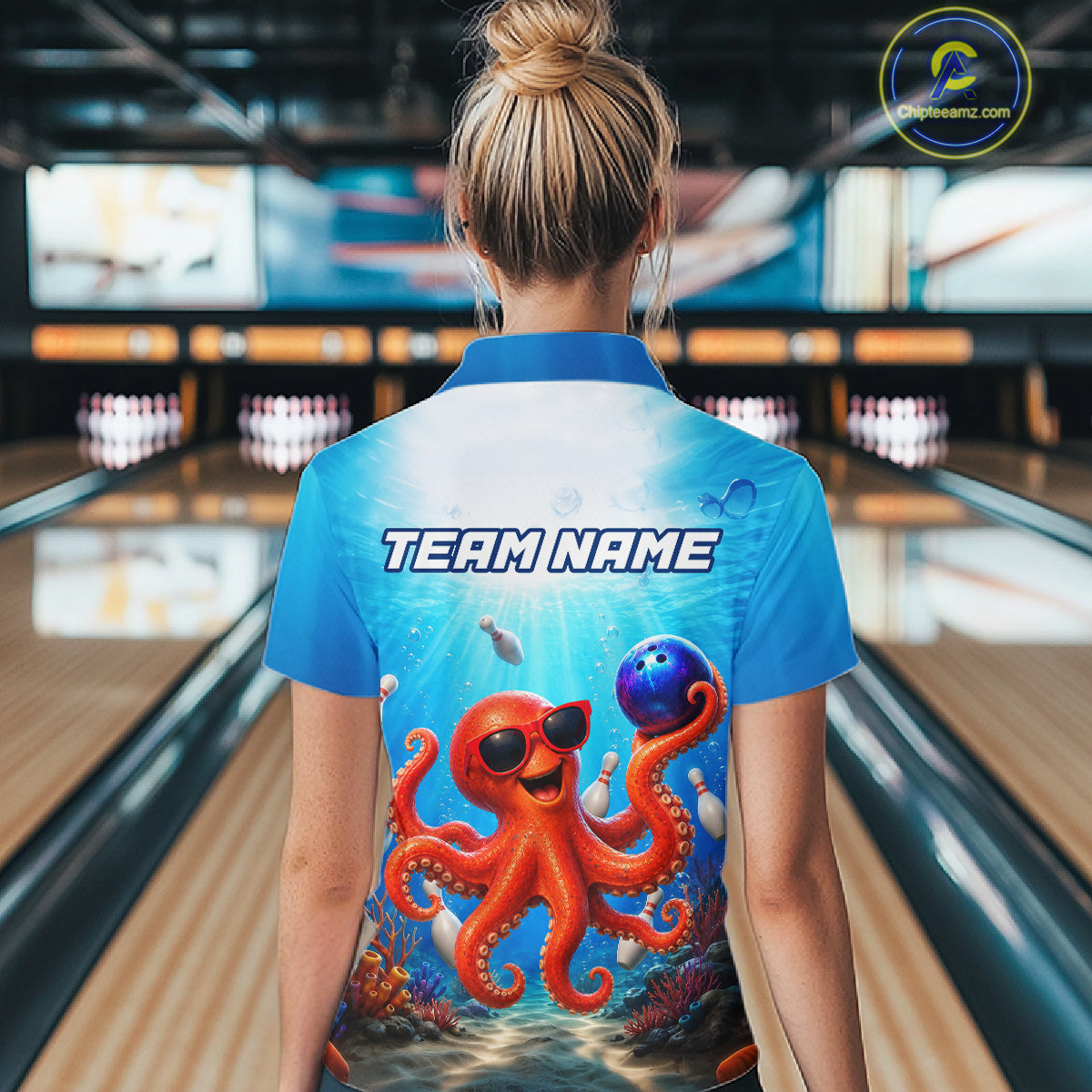 Person wearing a blue shirt with an octopus design and 'TEAM NAME' text in a bowling alley.