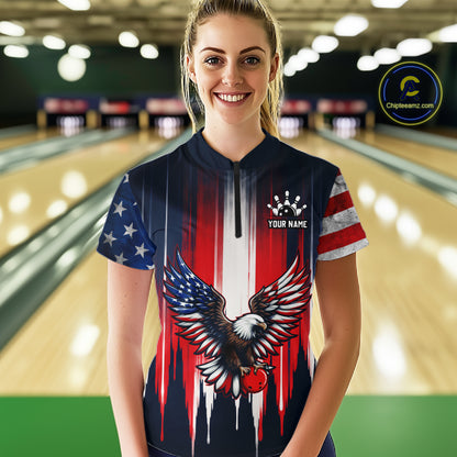 Person wearing a bowling shirt with an eagle and American flag design in a bowling alley.