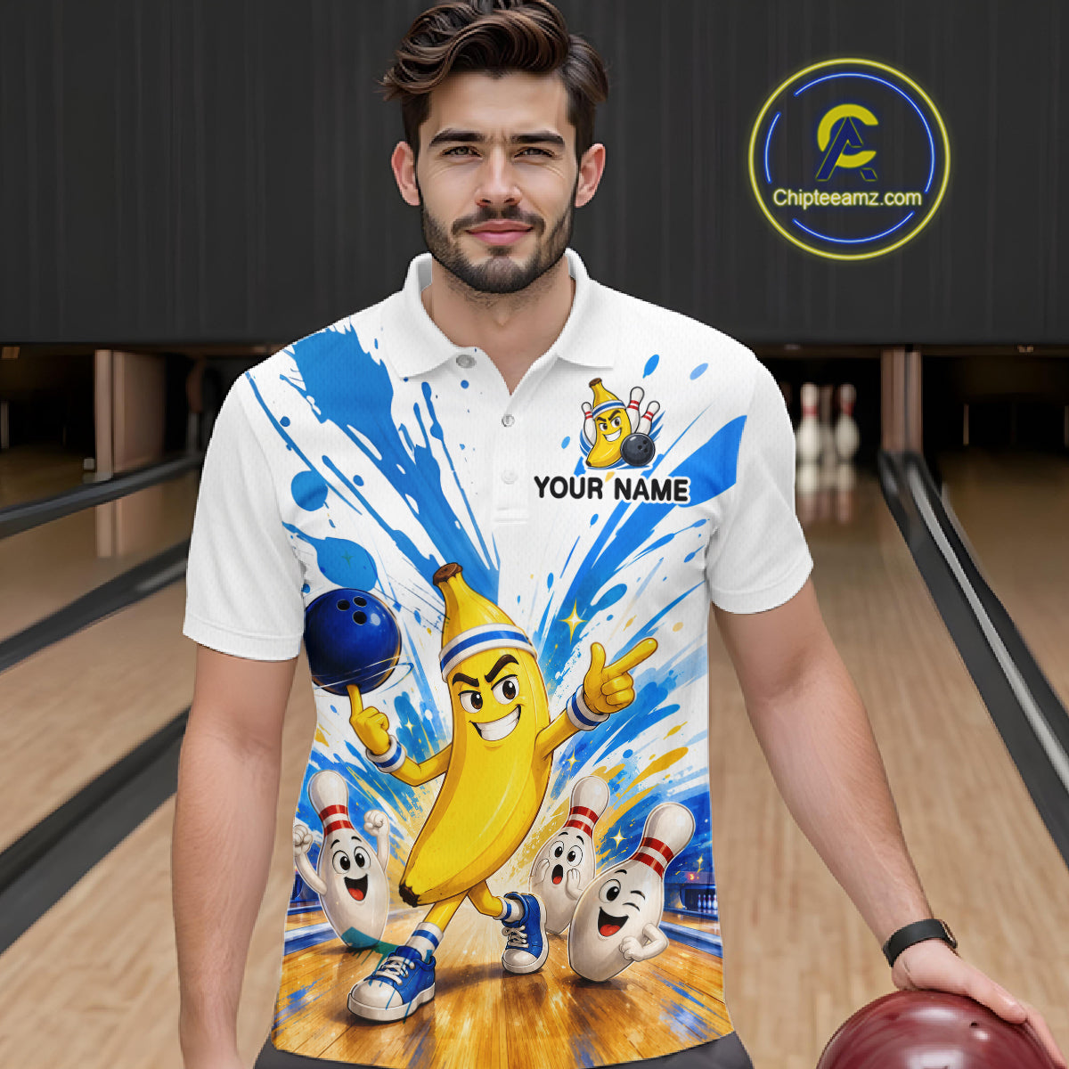 Man wearing a white polo shirt with a colorful design of a banana character and bowling pins in a bowling alley.