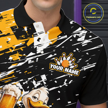 A close-up of a black short-sleeve polo shirt with a bold yellow, white, and black abstract graphic print, featuring a bowling pin graphic with the text 'YOUR NAME' and a cartoon duck holding a beer mug.
