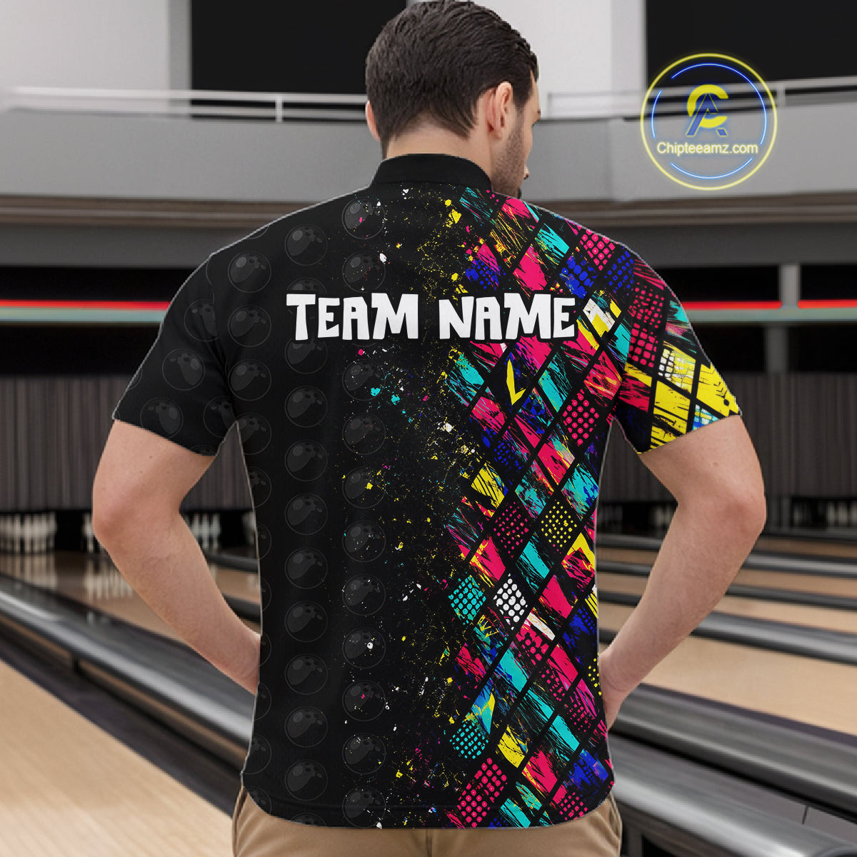 Person wearing a colorful bowling shirt with 'TEAM NAME' text at a bowling alley.