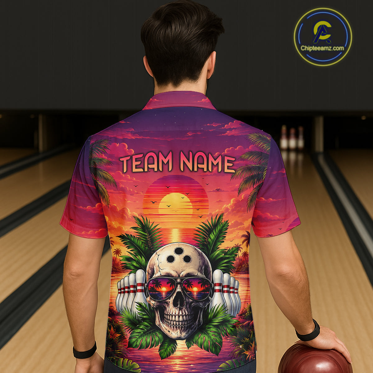 Person wearing a colorful bowling shirt with a skull design and 'Team Name' text in a bowling alley.