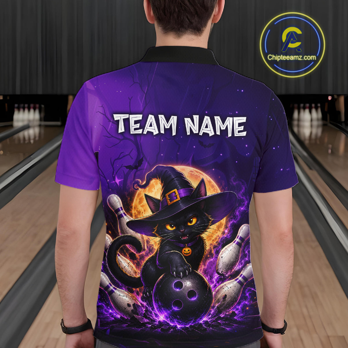 A person viewed from the back wearing a purple short-sleeve polo shirt with a large Halloween-themed graphic of a black cat in a witch hat holding bowling pins, with 'TEAM NAME' printed across the upper back. 